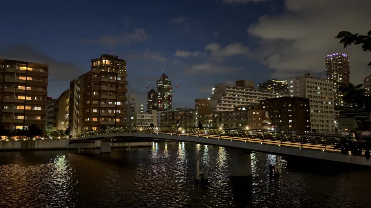 夜晚的城市景观与照明桥在平静的河流反射城市灯光视频素材