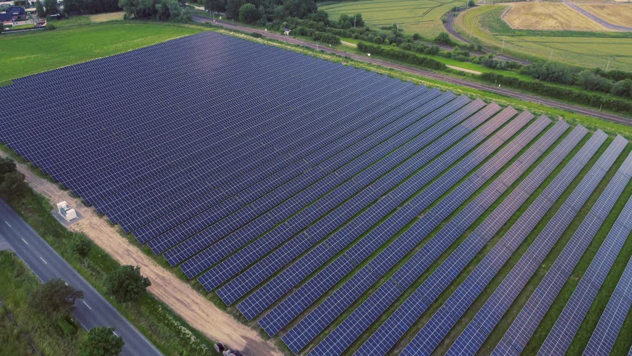 太阳能电池板与铁路和农村景观背景。视频素材