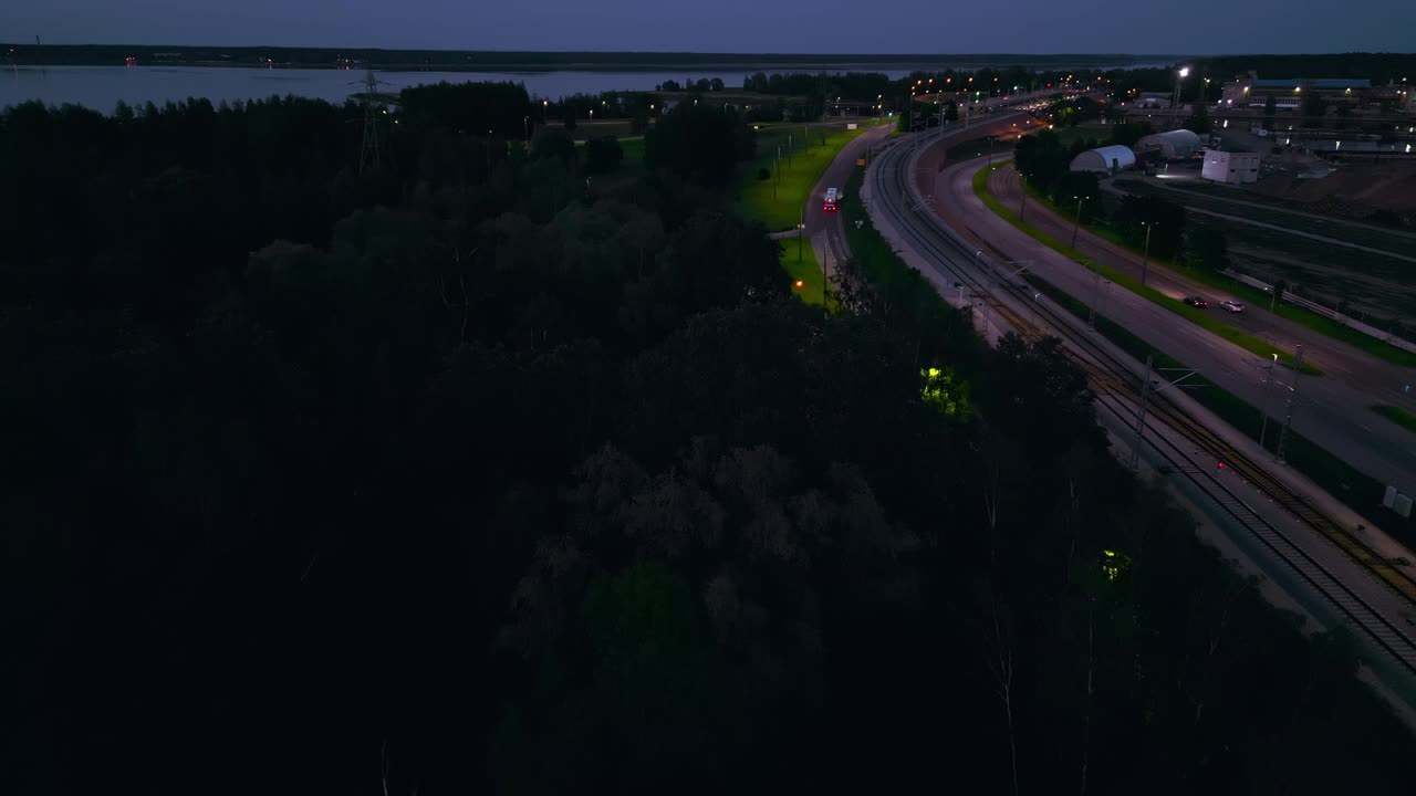 黄昏时的鸟瞰图显示高速公路、城市景观、森林、水。城市绿化，湖畔，宁静的基础设施视频素材