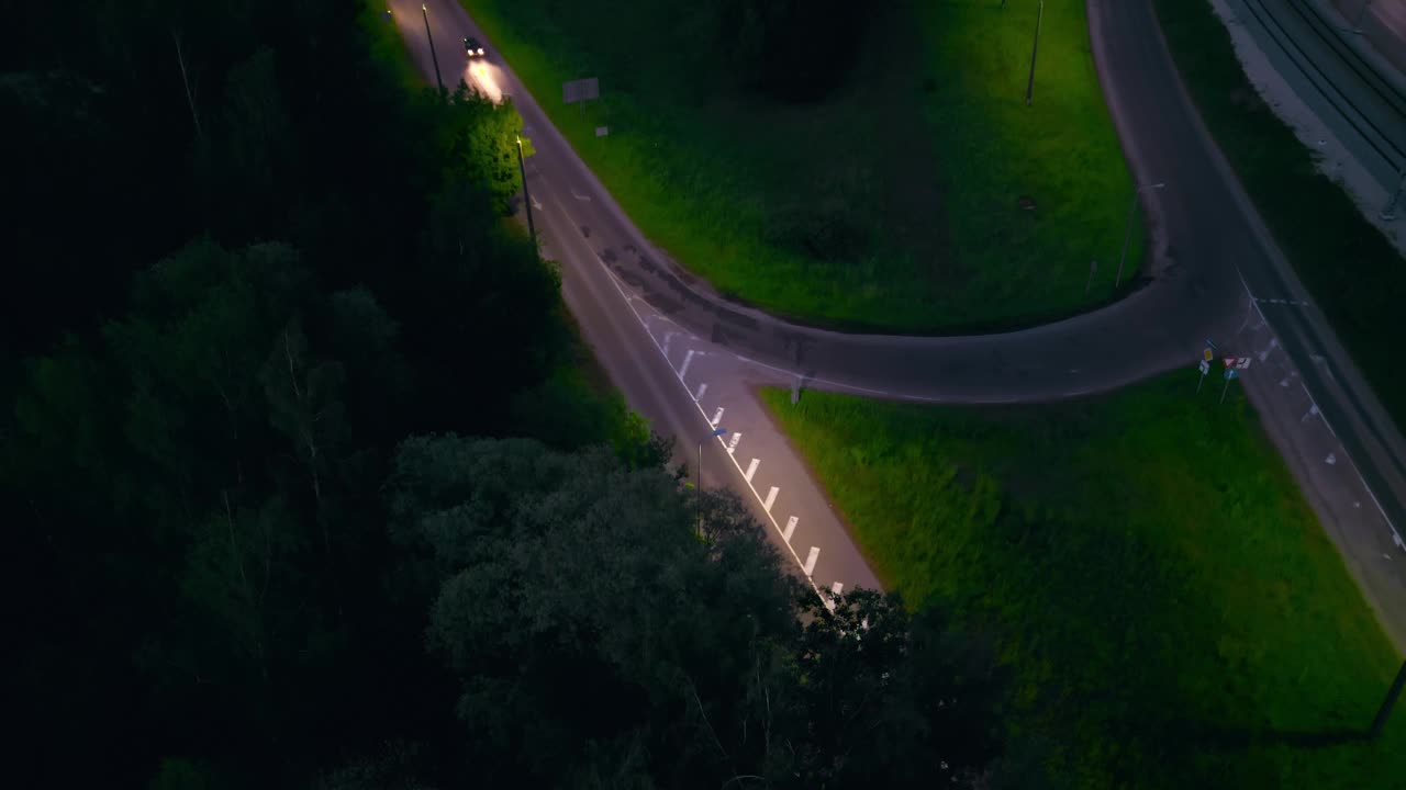 夜间在十字路口附近的道路上的汽车鸟瞰图，显示城市景观和交通灯视频素材