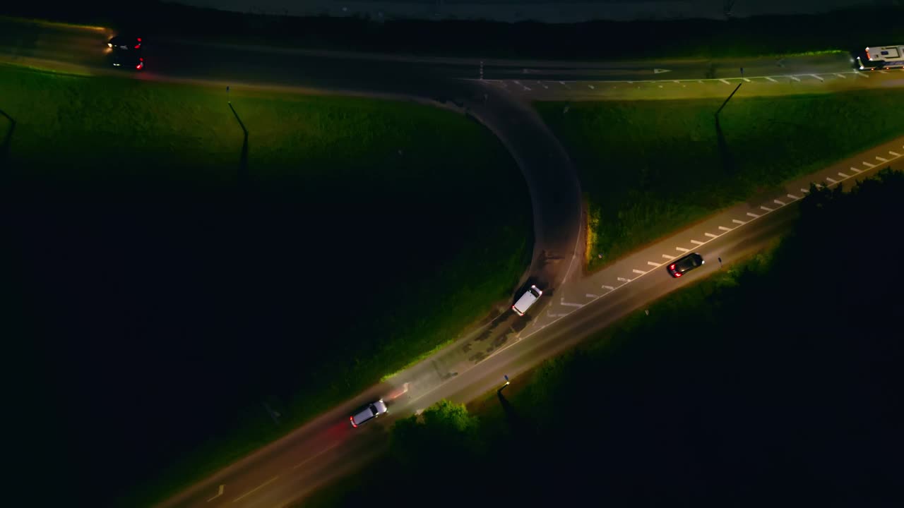 捕捉夜间交通通过弯曲道路的航拍画面，实现实时观看视频素材