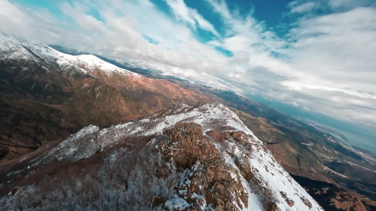 多云的天空下，白雪覆盖的山脊，鸟瞰图视频素材