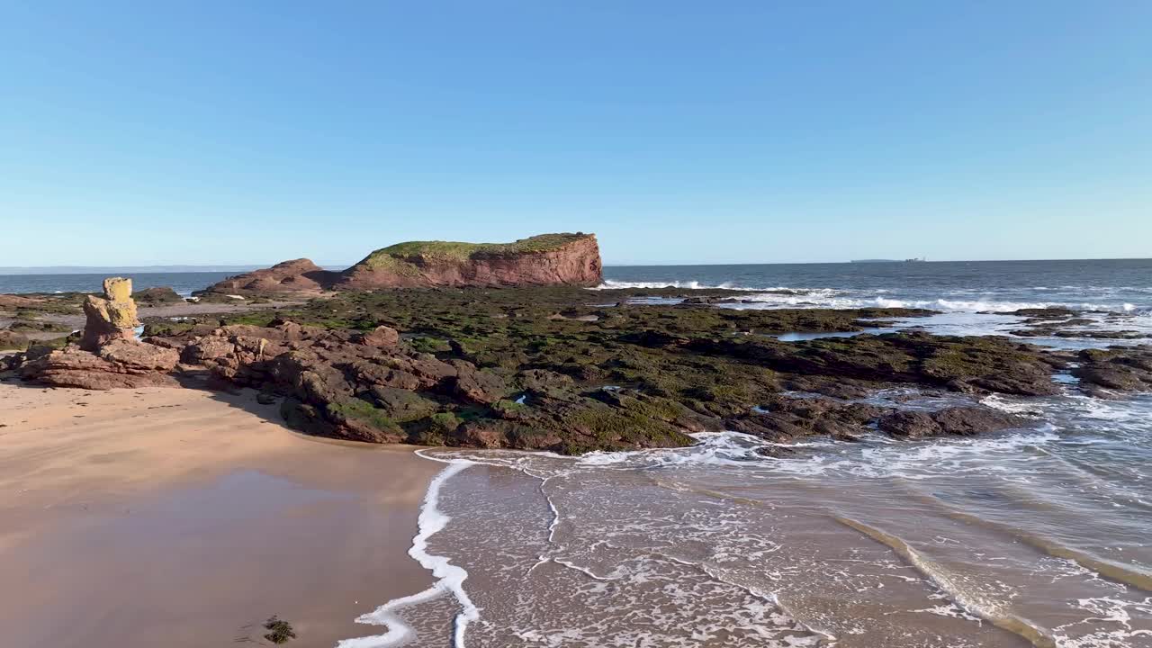 鸟瞰岩石海岸和海浪，北贝里克，苏格兰。视频素材