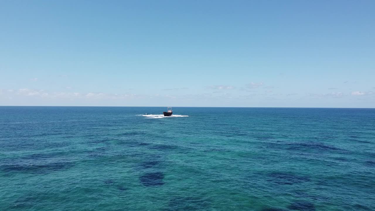 MV Demetrios II沉船的鸟瞰图，在明亮的天空下，搁浅在海岸清澈的蓝色海水中视频素材