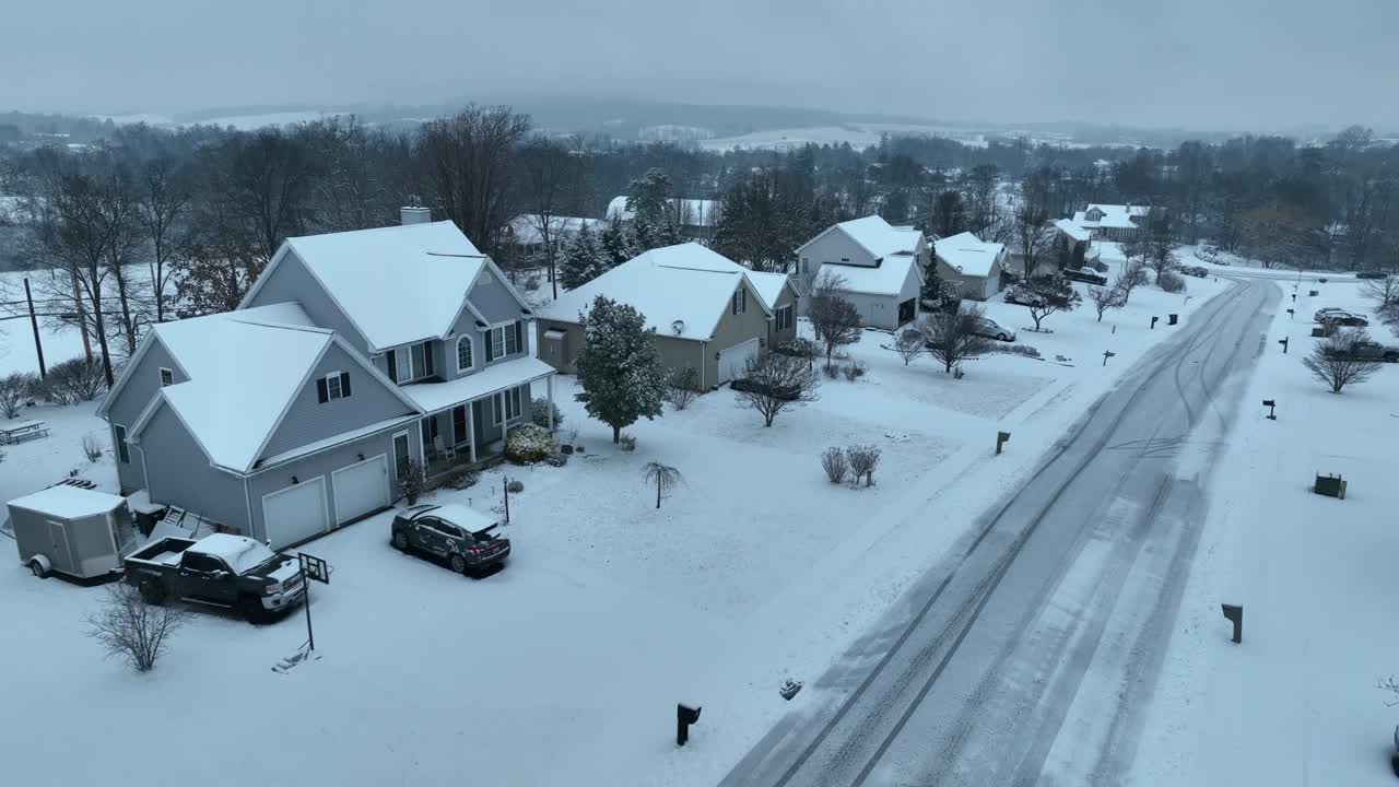 灰蒙蒙的冬日里，美国社区的雪屋和住宅。雪后泥泞的街道。通过飞行进行空中传递。视频素材