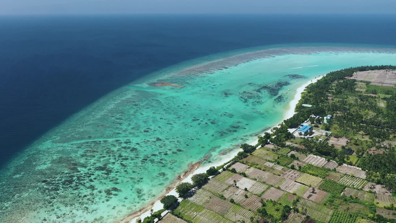 热带岛屿鸟瞰图，马尔代夫泻湖边的田野和房屋。视频素材