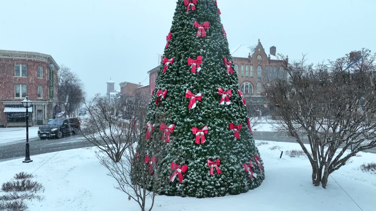 美国城市下雪，环岛中心装饰着圣诞树。冬天的雪从美国的天空落下。空中倾斜向上拍摄。视频素材