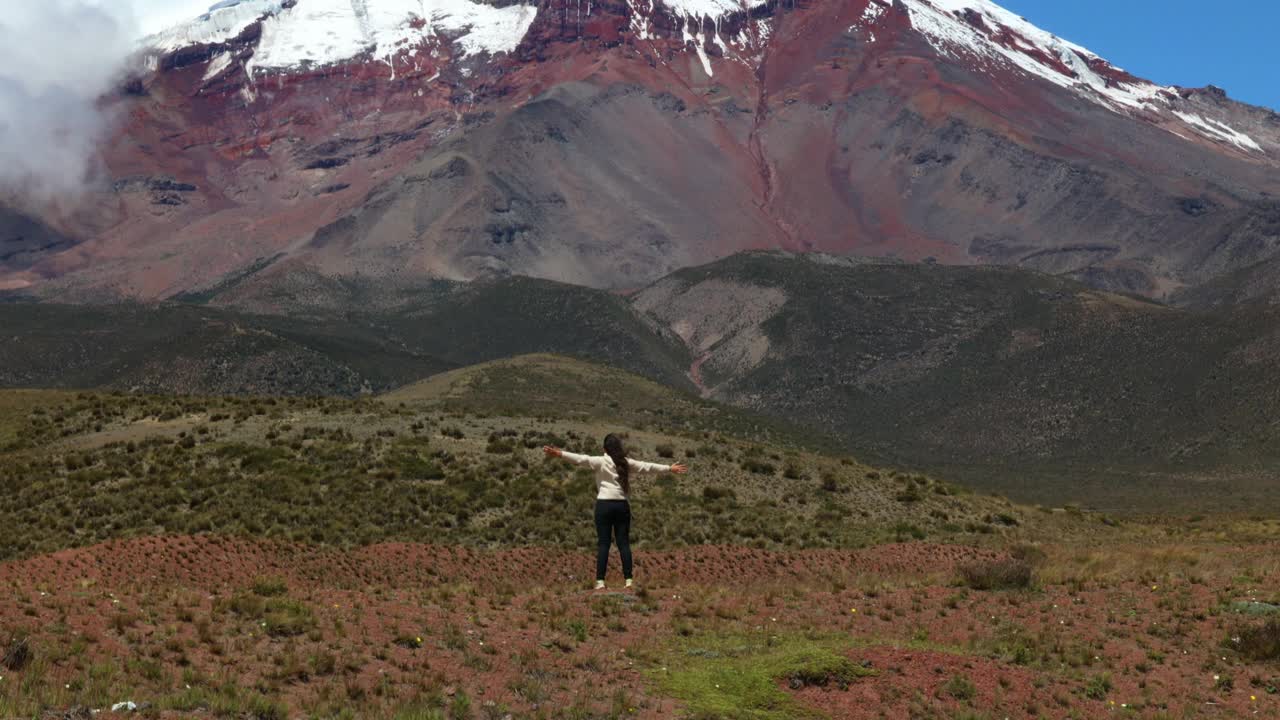 厄瓜多尔的钦博拉索火山(海拔6263米)，一名拉丁裔女子张开双臂面对火山视频素材