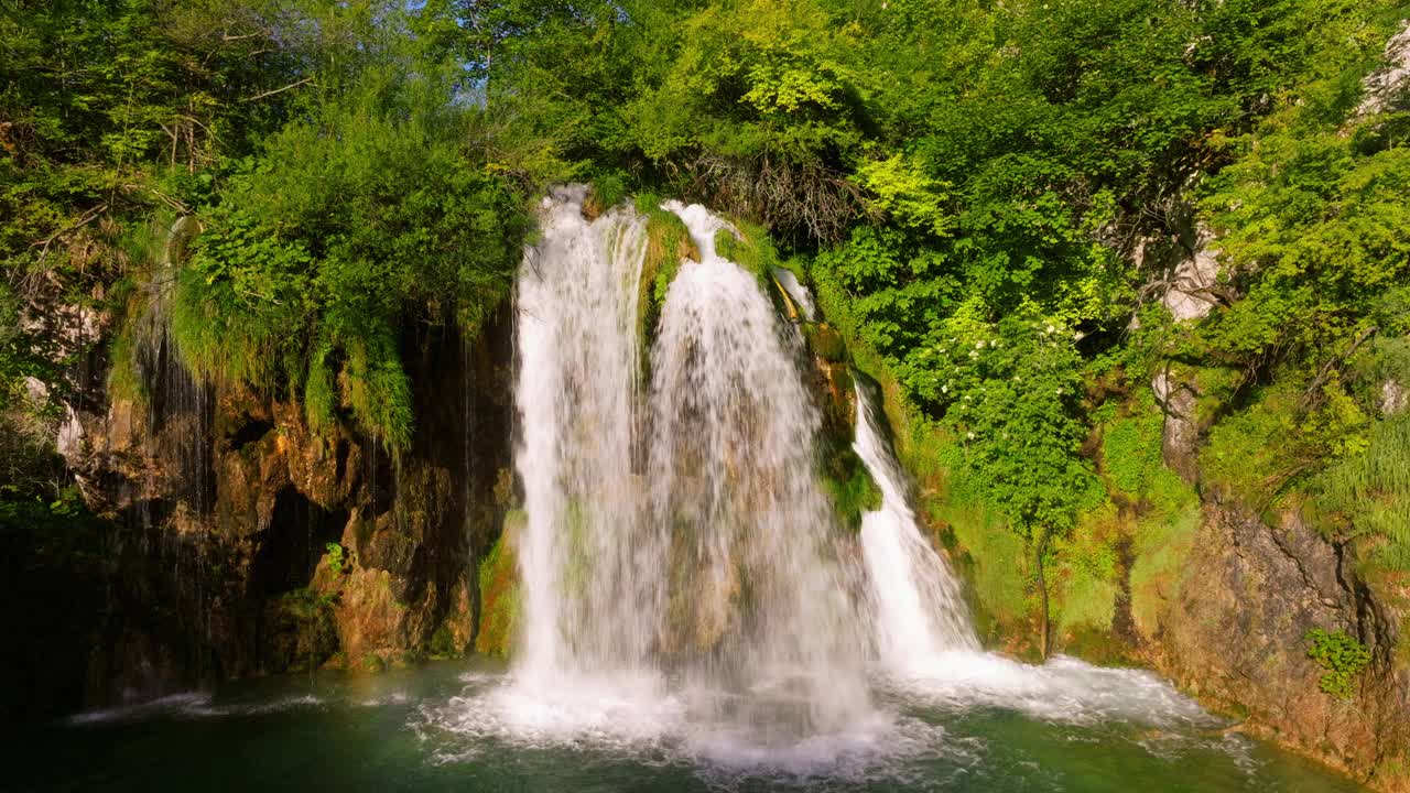 风景秀丽的伽洛瓦茨瀑布在克罗地亚的普利特维采湖国家公园里溅到河上。无人机上升拍摄视频下载