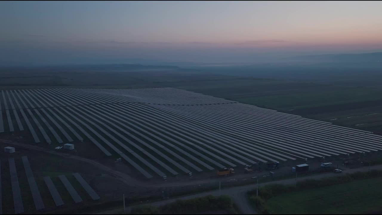 一个巨大的太阳能农场在黄昏的乡村景观，鸟瞰图视频下载