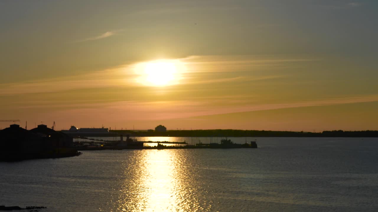 爱沙尼亚塔林港位于欧洲波罗的海，美丽的日落，波罗的海在夜晚和夏天都可以看到。橙色和蓝色的天空，海鸥在飞翔，船只和小船视频下载