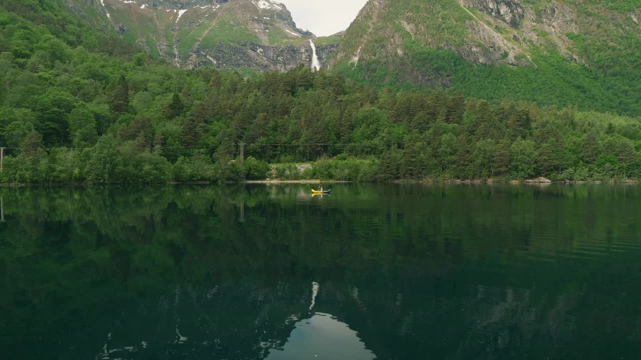 孤独的皮艇欣赏挪威湖的美景，鸟瞰视频下载
