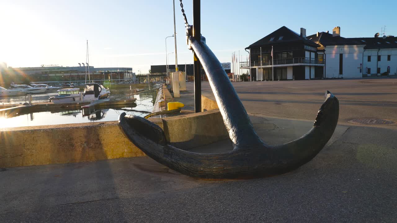视频以4K的形式展示了位于欧洲波罗的海国家塔林港的一个大型金属锚。背景是蓝天白云，游艇和船只停靠在波罗的海。视频下载