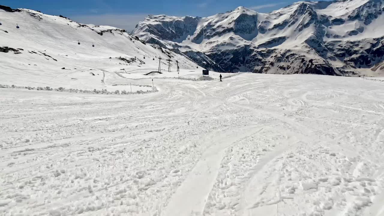 在一个阳光明媚的日子里，在阿尔卑斯山的雪坡上滑雪视频素材