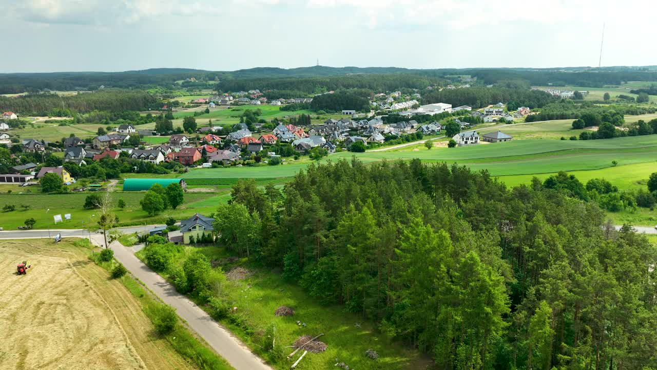 Iława乡村景观鸟瞰图，展示了一个小村庄的住宅、田野和周围的森林地区，捕捉了宁静的乡村氛围视频素材