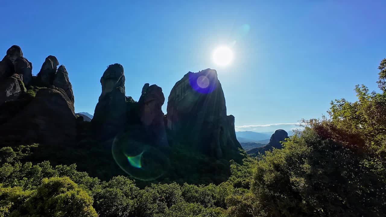 壮丽的岩层在迈泰奥拉，希腊在明亮的阳光下与郁郁葱葱的绿色植物视频素材