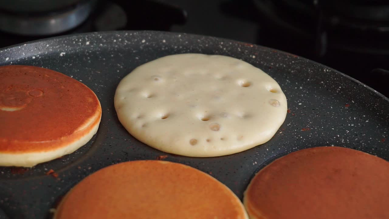 用锅铲把锅里煮好的煎饼翻过来视频素材