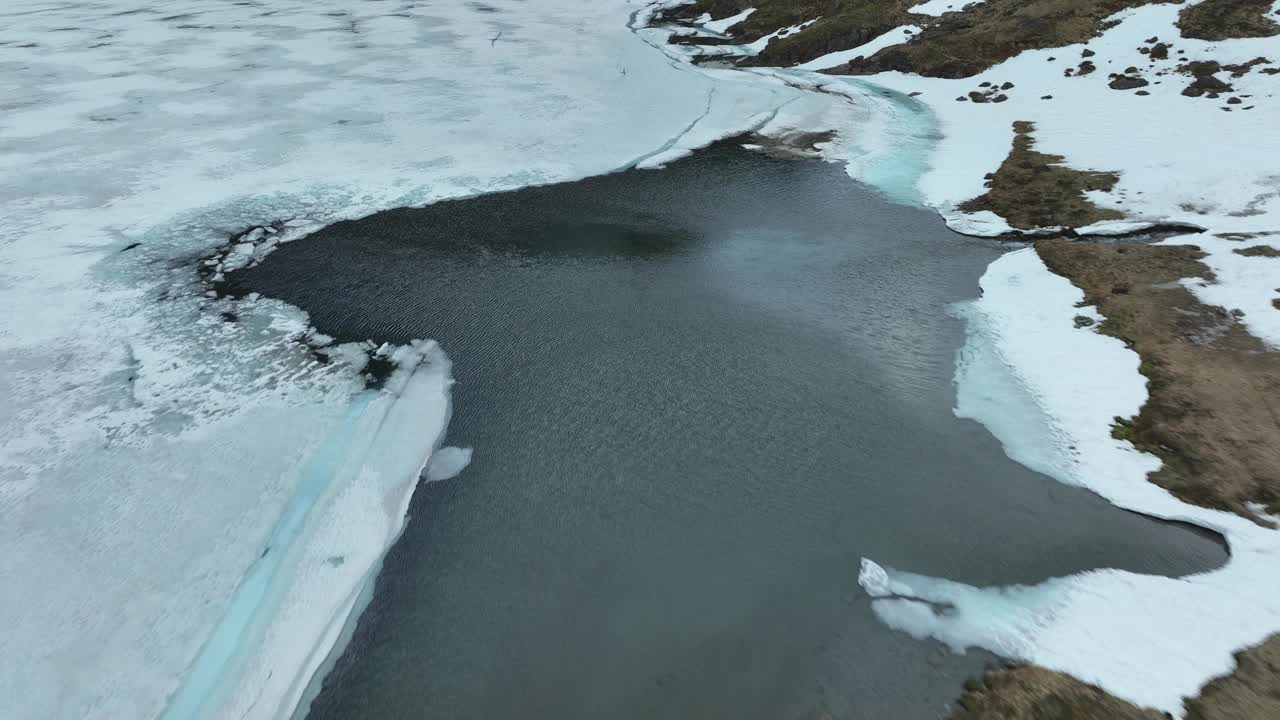 鸟瞰图，挪威部分结冰的湖泊，被雪覆盖的海岸和周围的景观视频素材