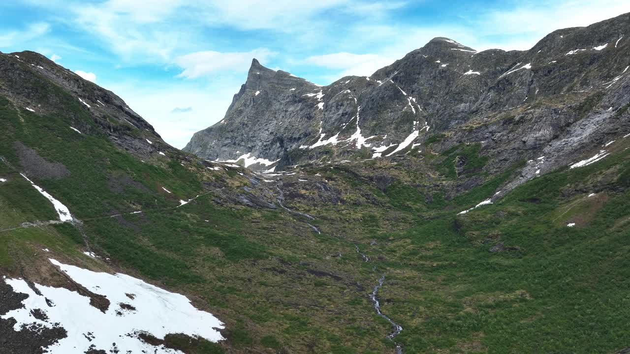 令人惊叹的鸟瞰图，郁郁葱葱的绿色山谷被雪山包围视频素材