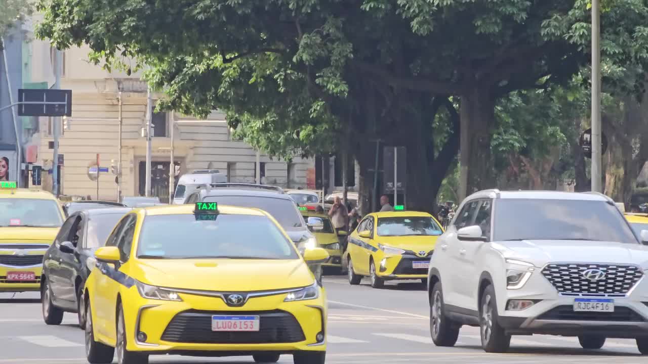 在里约热内卢繁忙的大街上行驶的出租车和私家车视频下载