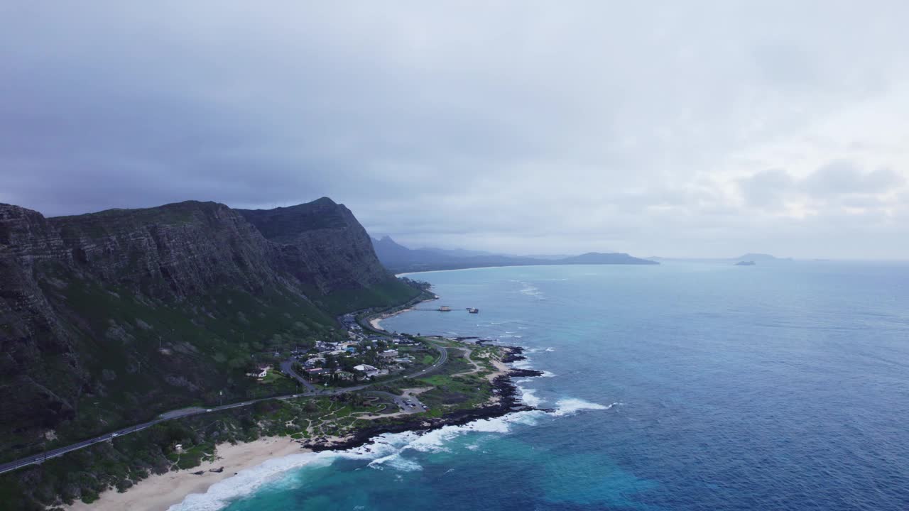 瓦胡岛北岸的鸟瞰图显示，雄伟的悬崖与充满活力的蓝色海洋相遇，宁静的海滩和一个小型沿海社区坐落在基地。视频素材