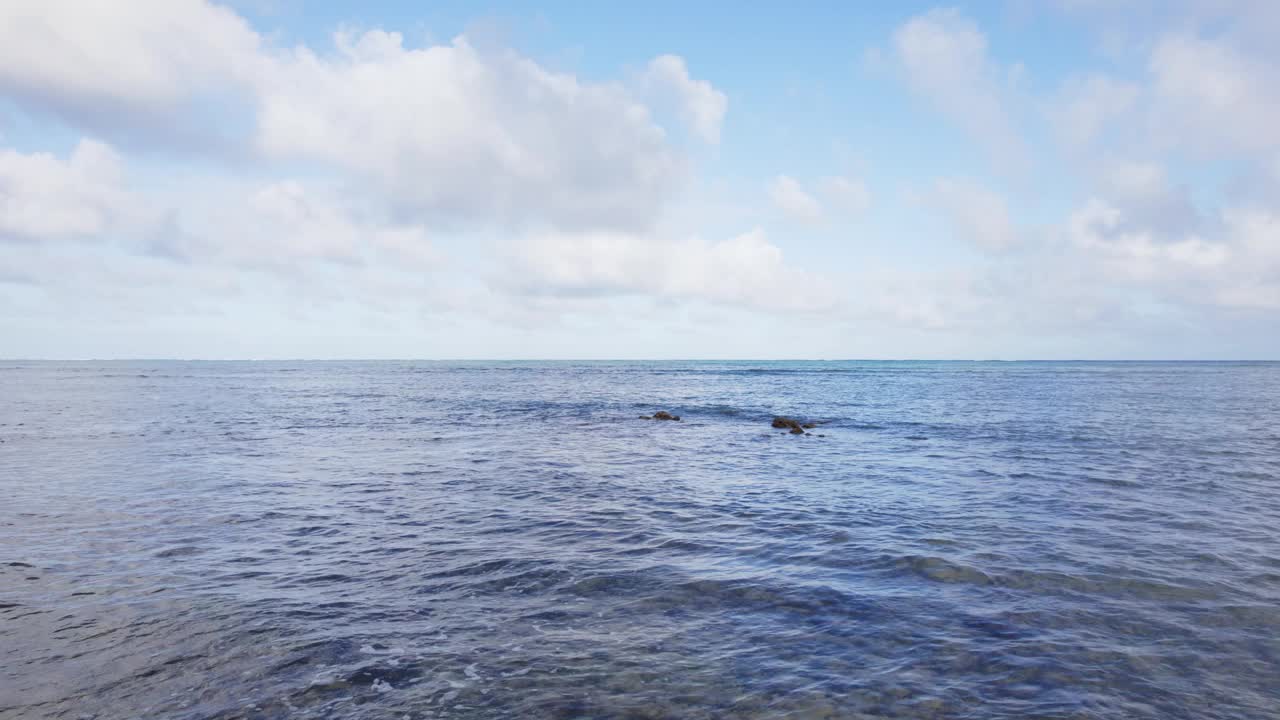 瓦胡岛海岸晶莹剔透的海水迷人的景色。宁静的蓝色广阔和可见的珊瑚礁在表面下突出了岛屿的自然美景。视频素材