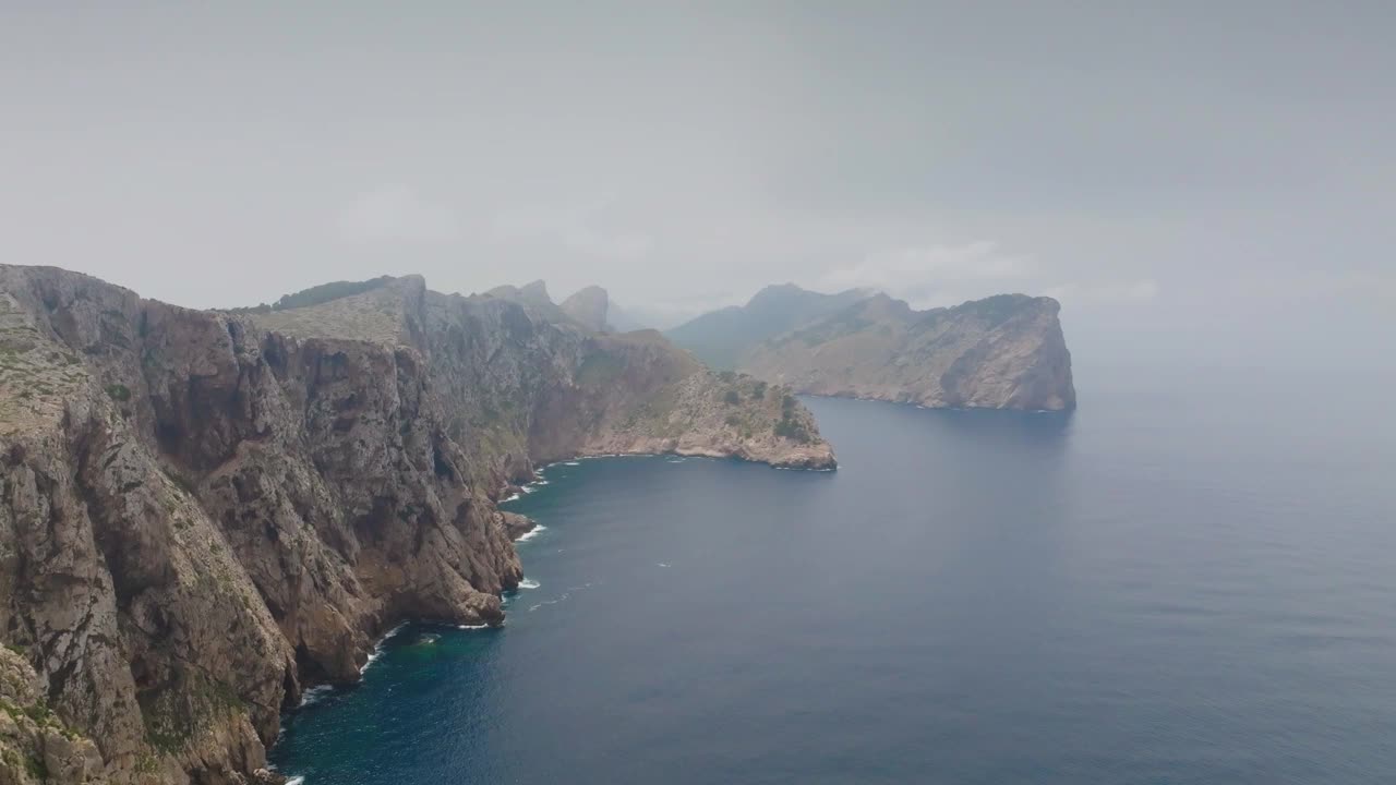 空中陡峭崎岖的石灰岩海岸线悬崖附近的蓝色的水，马略卡岛视频素材