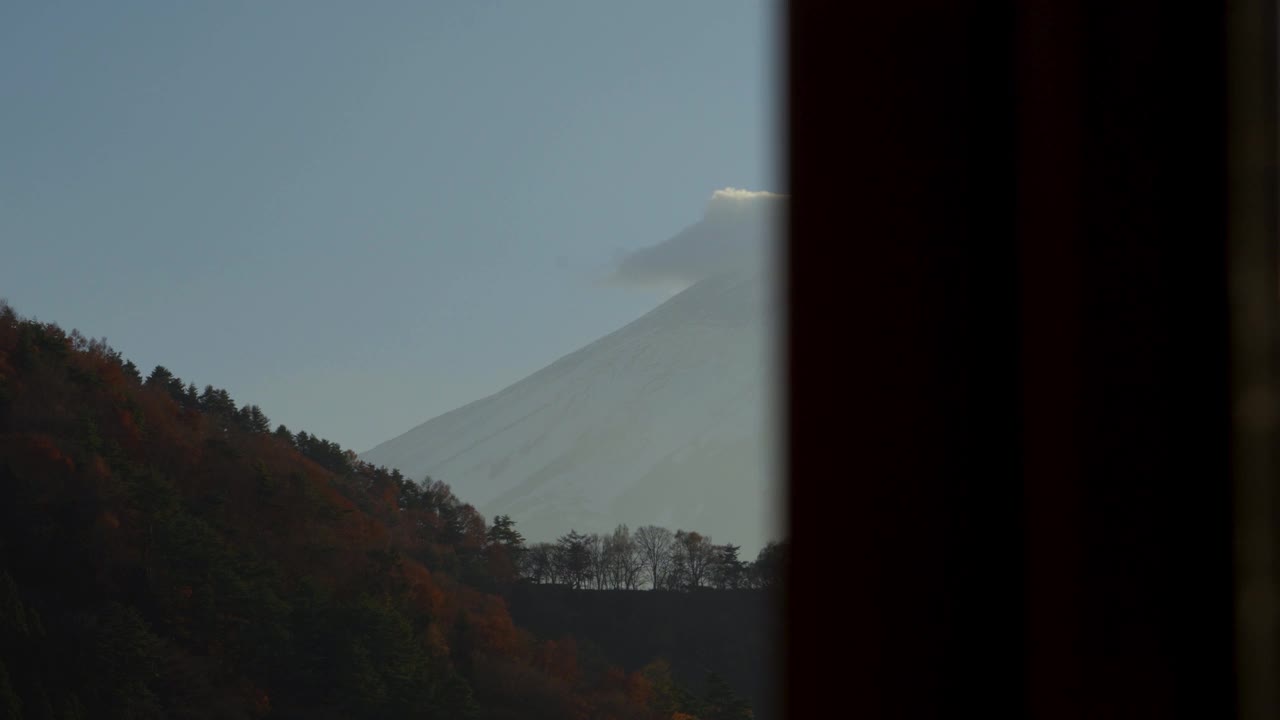 在秋光中透过窗户看到白雪皑皑的富士山和一缕云视频素材