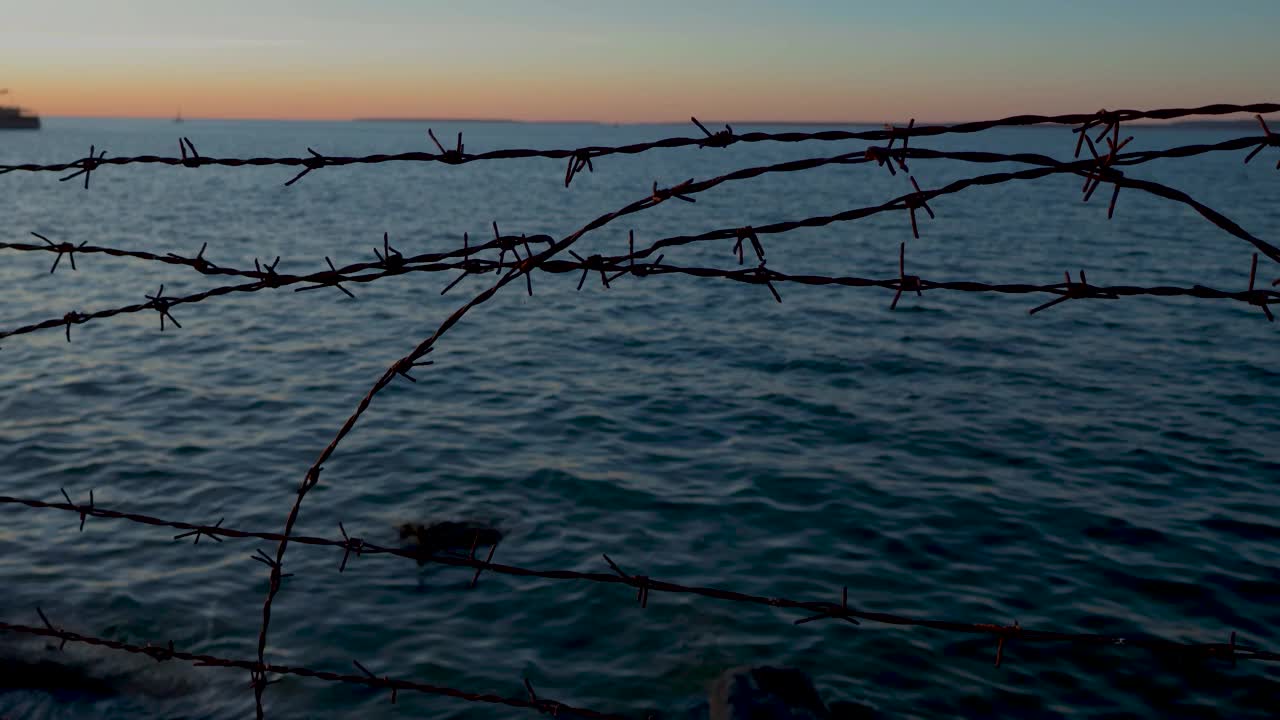 视频功能塔林港在日落的夜晚与波罗的海，船只和船只的背景时间。通过铁丝网拍摄，使镜头充满活力的色彩非常电影化。视频素材