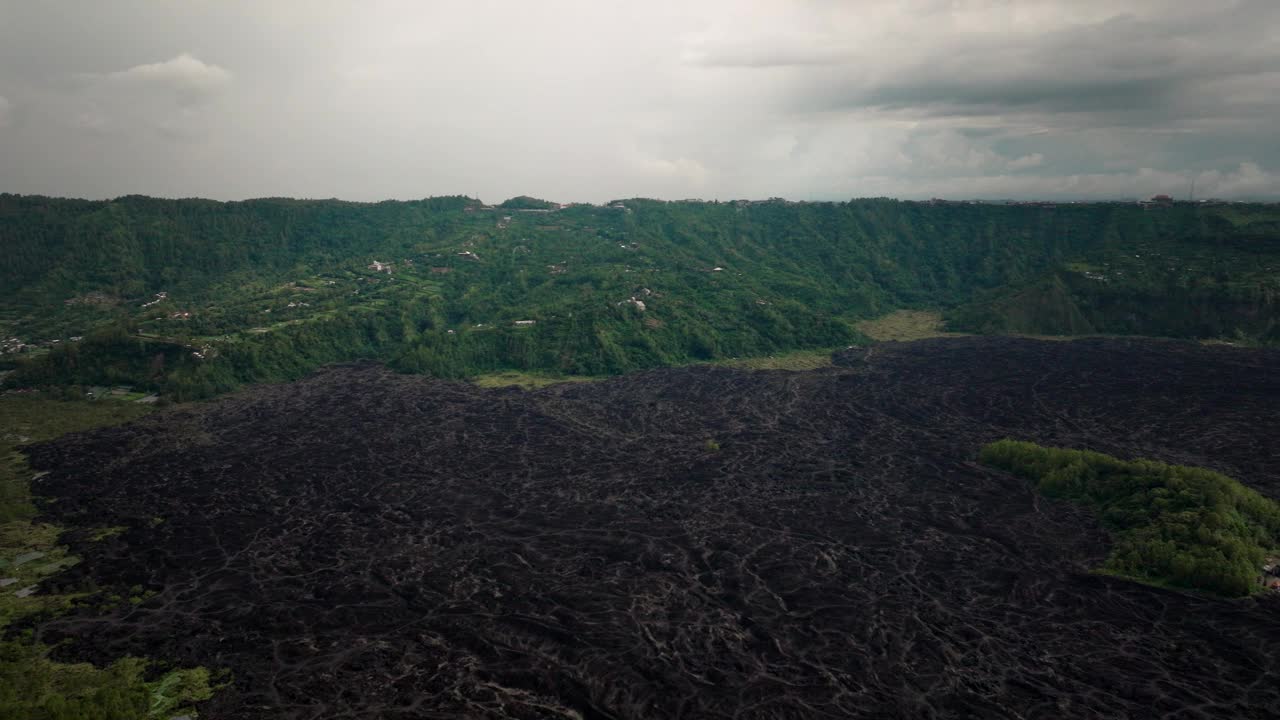 鸟瞰印尼巴厘岛金塔马尼巴图尔火山喷发的熔岩场。平移镜头视频素材