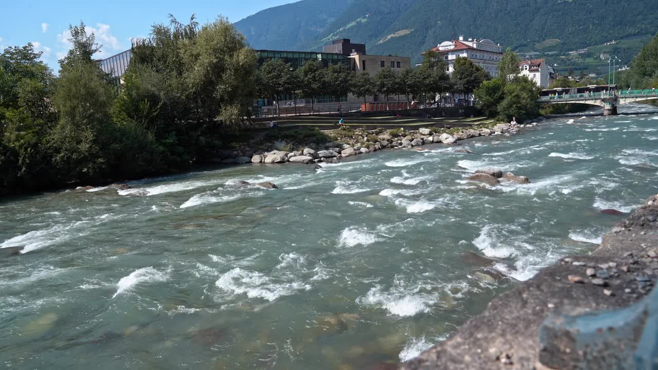 夏日里，意大利梅拉诺市的帕瑟河在明亮的阳光下，背景中有一座桥。视频下载