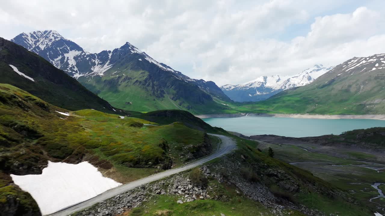 风景秀丽的鸟瞰山塞尼斯湖被群山环绕，通过郁郁葱葱的绿色景观，具有空旷蜿蜒的道路。视频素材