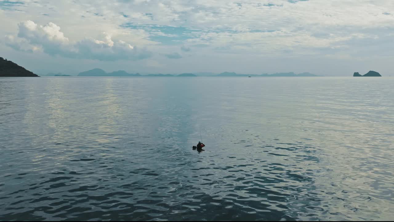 航拍的渔民在温暖的热带海洋，云在天空，岛屿在地平线上视频下载