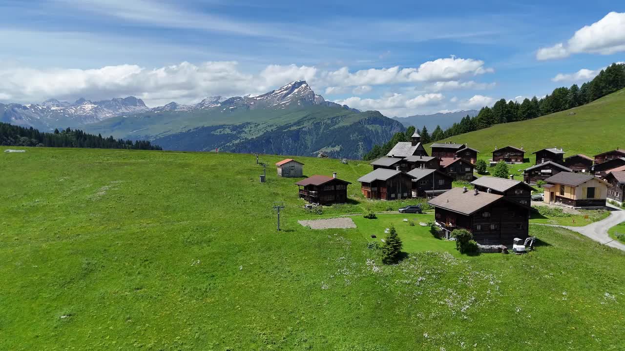 迷人的高山村庄奥伯穆滕在瑞士与郁郁葱葱的绿色草地和山的背景视频素材