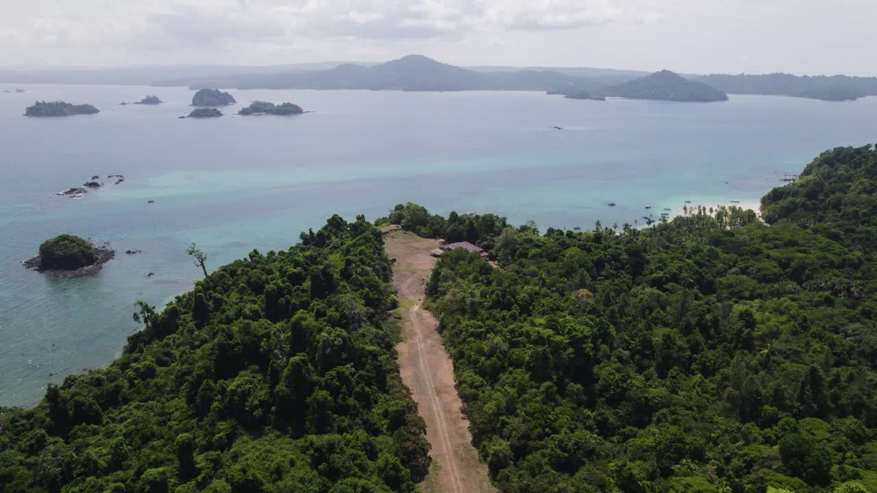 巴拿马科伊巴岛的鸟瞰图，展示了郁郁葱葱的绿色植物，风景秀丽的海岸线，多云的天空下宁静的水域。推进投篮视频素材