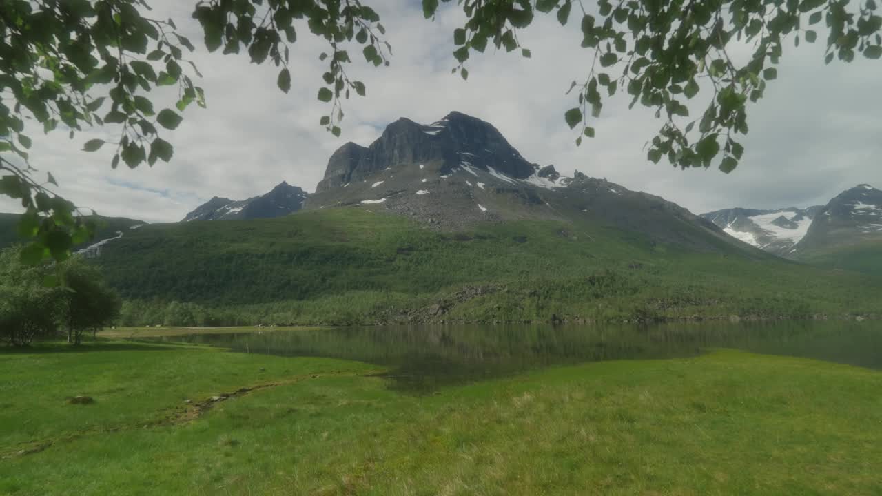 一对年轻夫妇在风景秀丽的内德达伦山谷徒步旅行，背景是山脉和湖泊视频素材