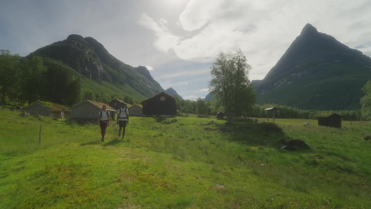 徒步旅行者探索Innerdalen山谷，背景是Renndølsetra农场和innerdalst<s:1> rnet峰视频素材