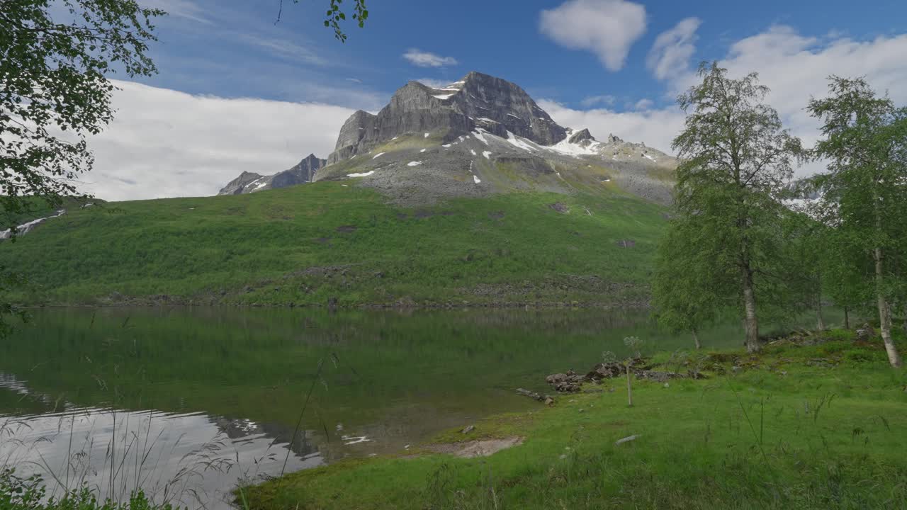 两名徒步旅行者探索风景秀丽的挪威内德达伦山谷，周围是郁郁葱葱的绿色植物和宁静的湖泊视频素材