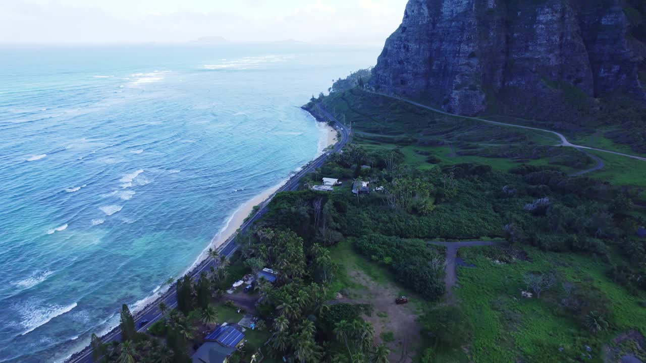 体验瓦胡岛海岸线的宁静之美，道路沿着原始的蓝色海水和郁郁葱葱的绿色景观蜿蜒而行。一个完美的逃避到大自然的宁静。视频素材