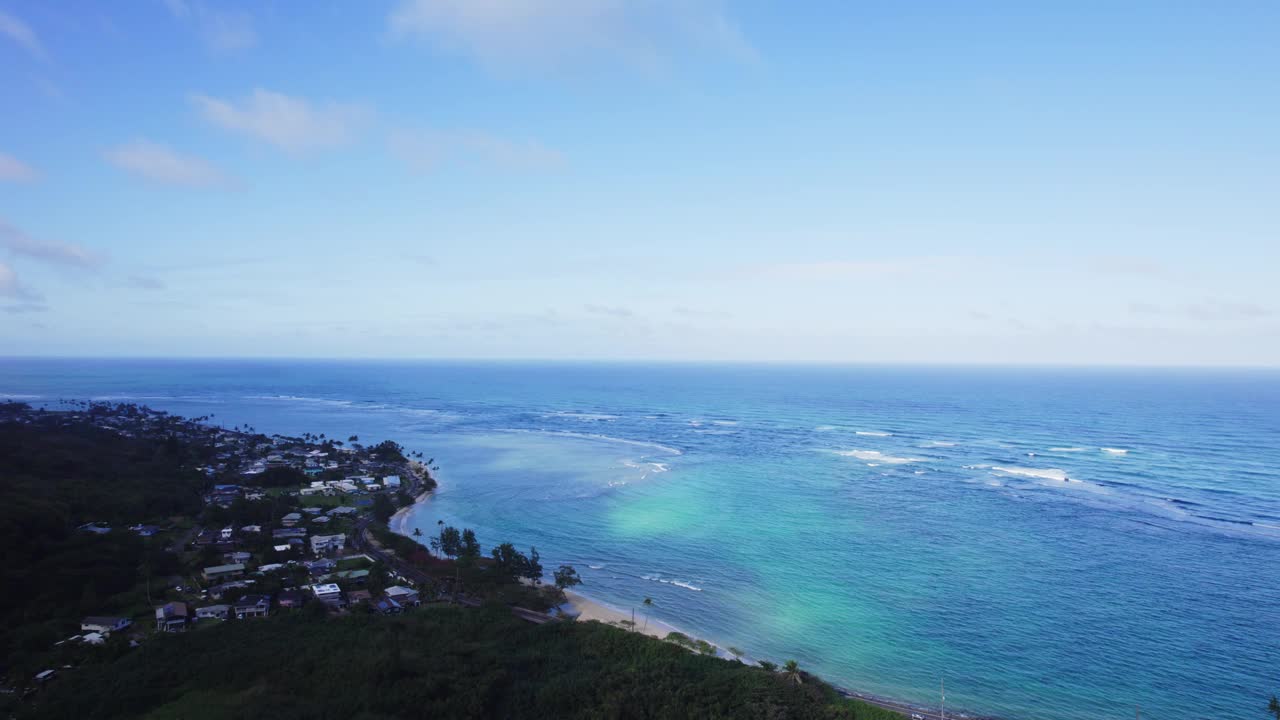 瓦胡岛海岸线令人惊叹的鸟瞰图，展示了清澈的蓝色海水，沙滩和明亮的蓝天下充满活力的沿海社区。视频素材