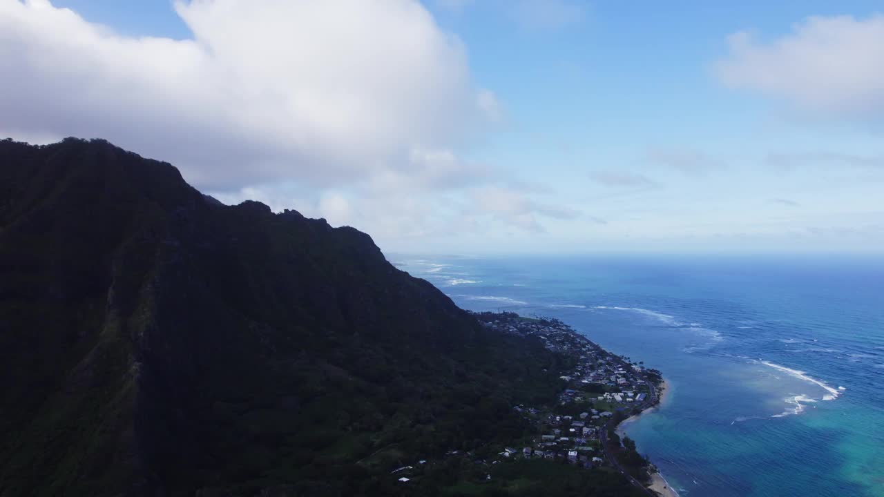 瓦胡岛海岸线的鸟瞰图，一边是郁郁葱葱的青山，另一边是广阔的蓝色海洋，展示了自然与文明的和谐。视频素材