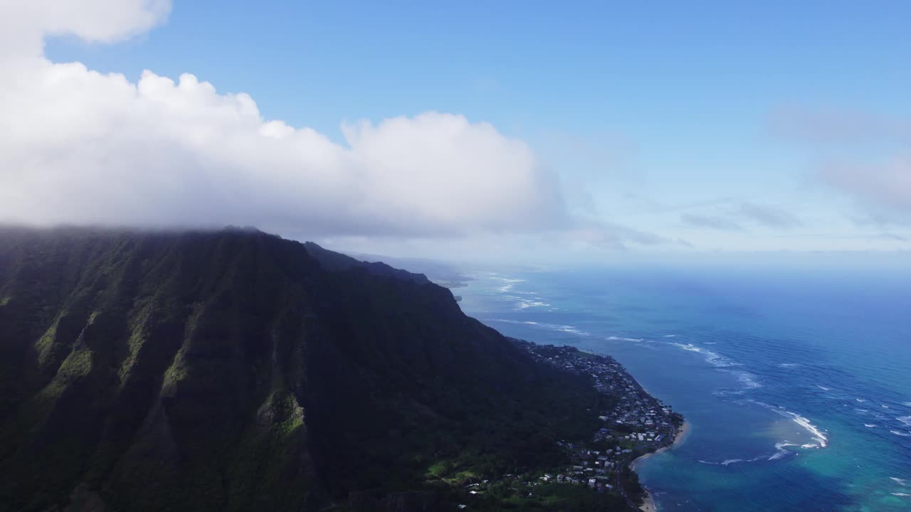 令人惊叹的瓦胡岛迷人海岸线鸟瞰图，郁郁葱葱的山脉与无尽的蓝色海洋相遇，捕捉到这个夏威夷天堂的宁静之美。视频素材