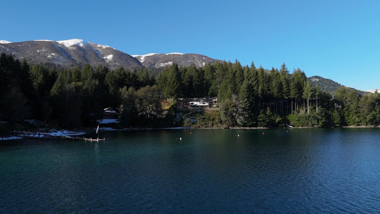 鸟瞰图上的码头在晶莹剔透的湖与白雪皑皑的海岸线视频素材