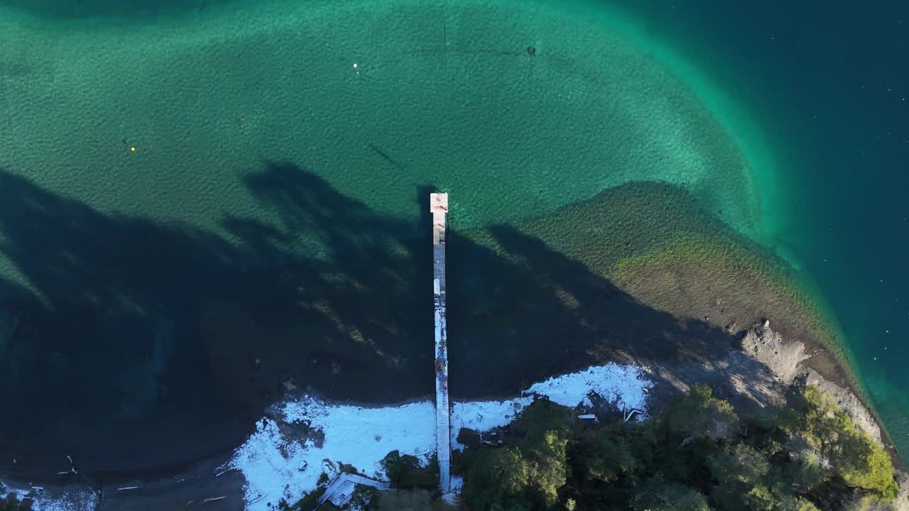 鸟瞰图上的码头在晶莹剔透的湖与白雪皑皑的海岸线视频下载