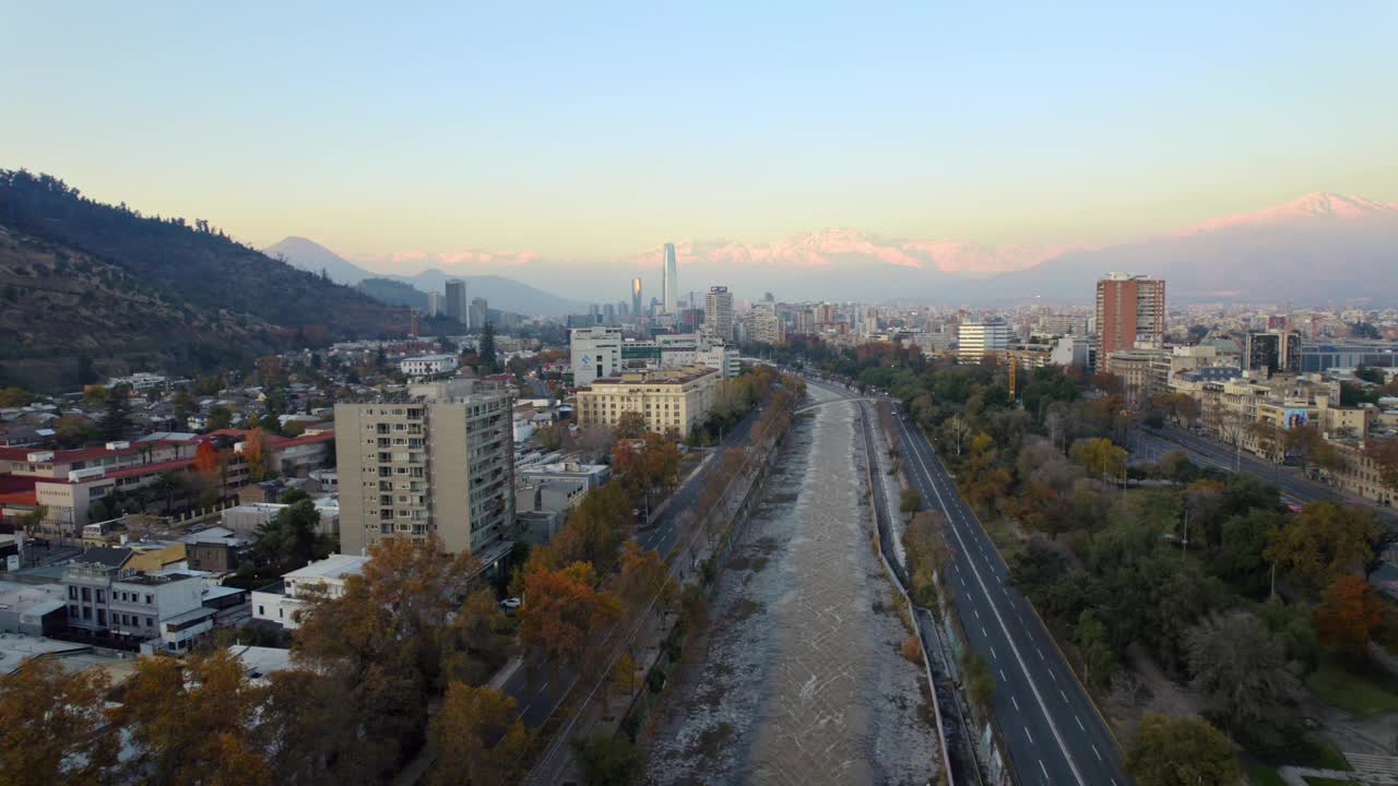 多丽鸟瞰图中的马波乔河与住宅建筑和安第斯山脉在日落的背景。视频素材