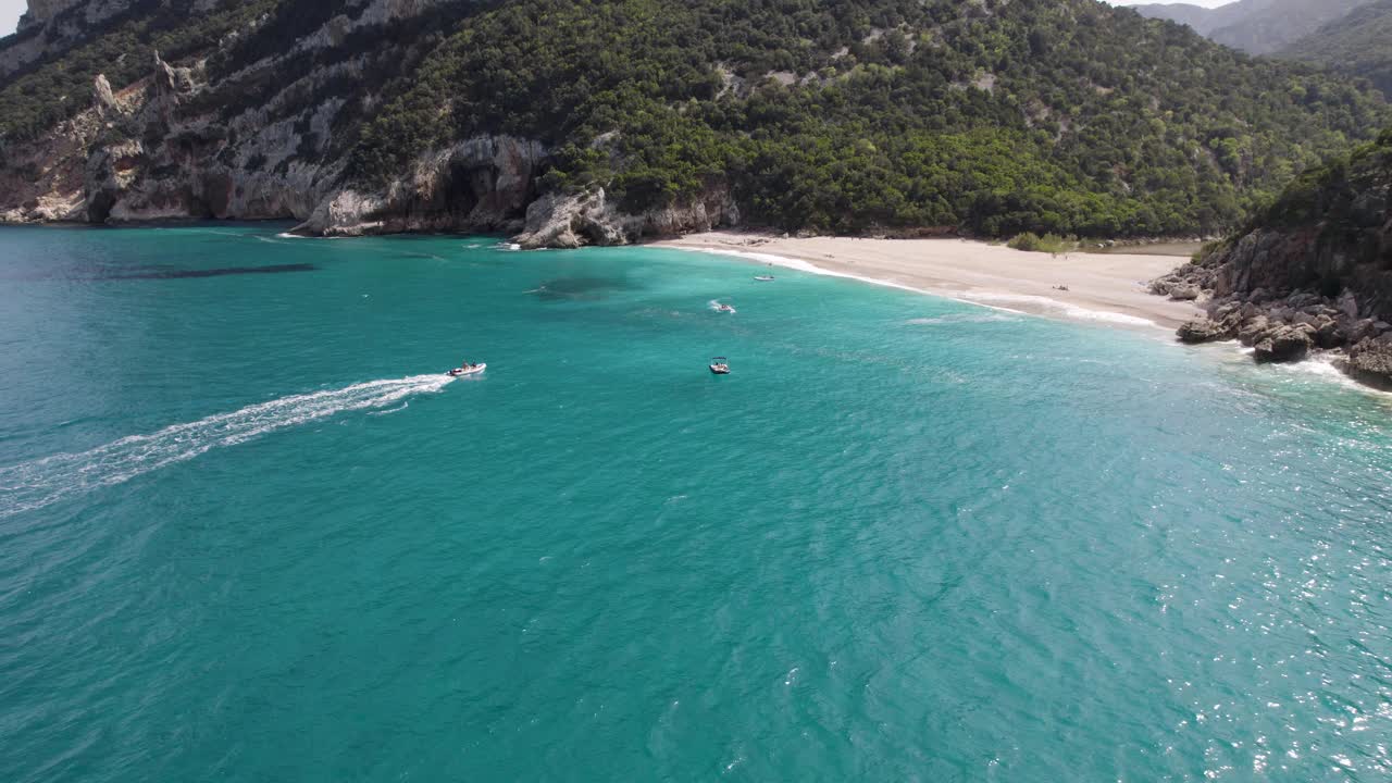 Cala Sisine海滩，海上有船。意大利撒丁岛奥罗塞湾鲍尼海岸。无人机回升视频素材