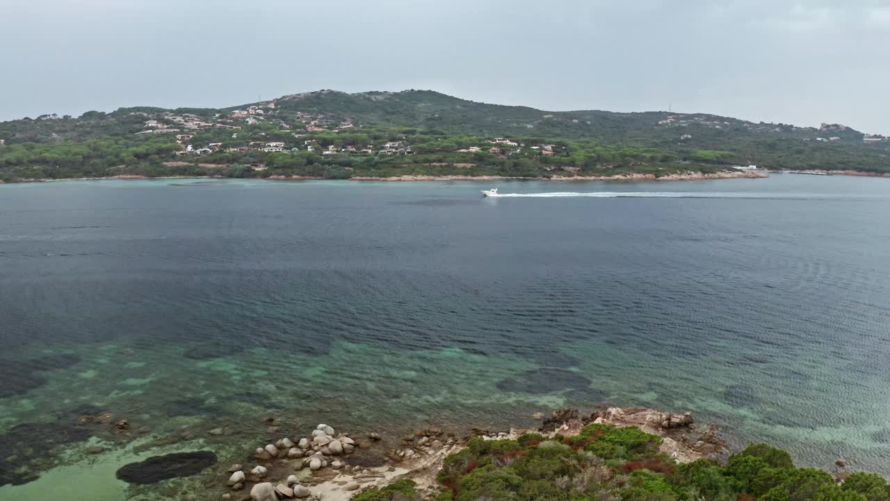 一艘快艇滑过撒丁岛宁静海湾清澈的海水视频素材