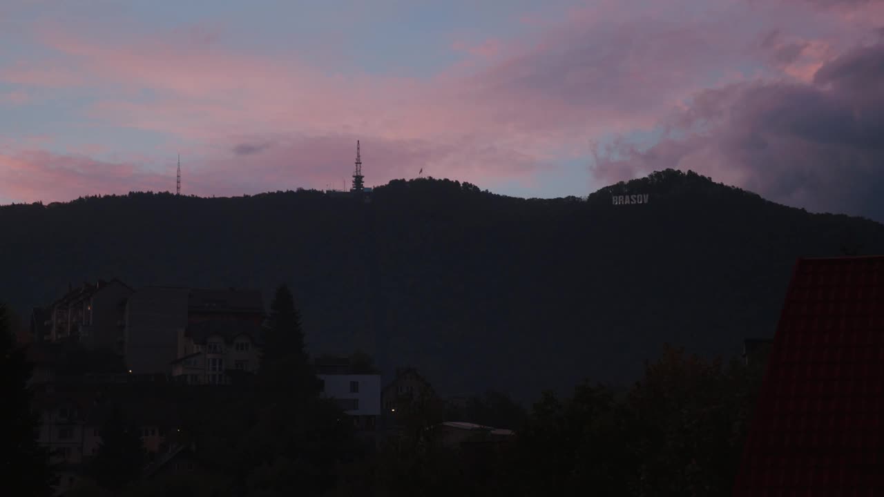 五颜六色的日落天空在一座山与建筑物的前景视频素材