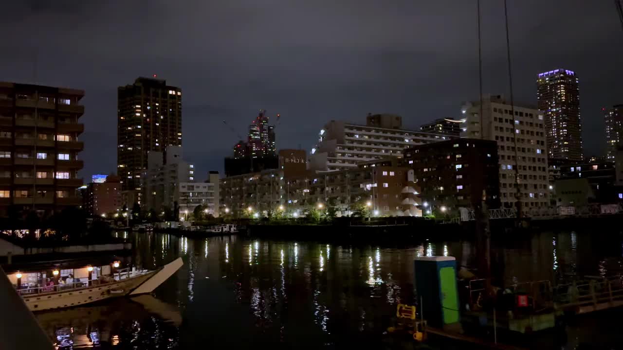 夜景东京天际线与城市灯光反射在河，充满活力的城市氛围视频素材