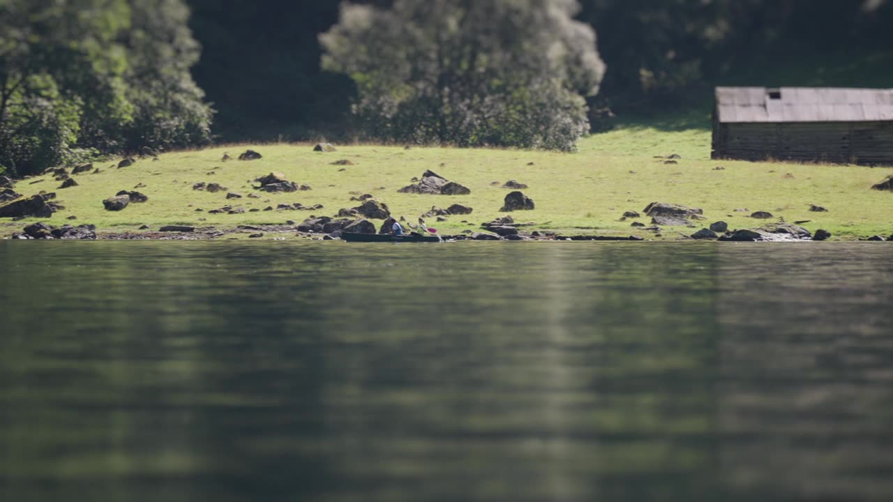 一个倾斜的视频，两个饱经风霜的木谷仓坐落在岩石峡湾海岸。微型效果增加了一个令人愉快的，玩具般的质量的场景。视频素材画面1